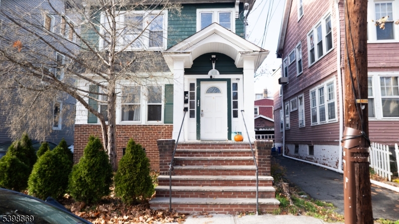 65 Poe Avenue Newark, NJ 07106 - Photo 2 of 18 a front view of a house with a yard