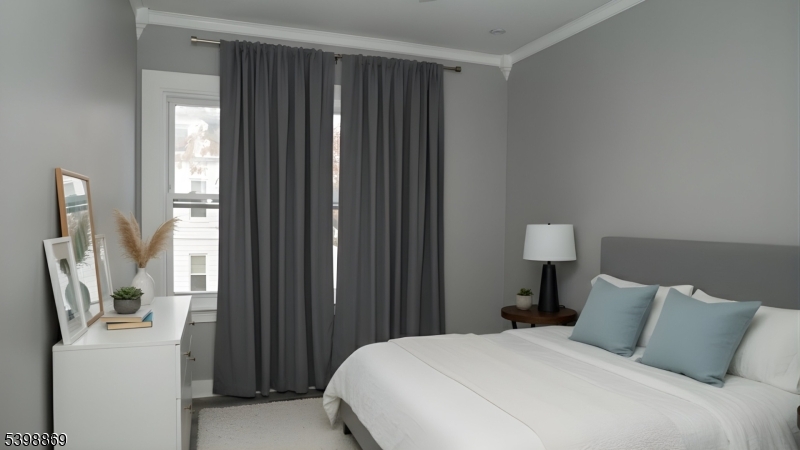 65 Poe Avenue Newark, NJ 07106 - Photo 5 of 18 a bedroom with a bed and a flat tv screen on a dresser