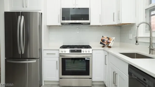a kitchen with stainless steel appliances granite countertop a refrigerator sink and stove