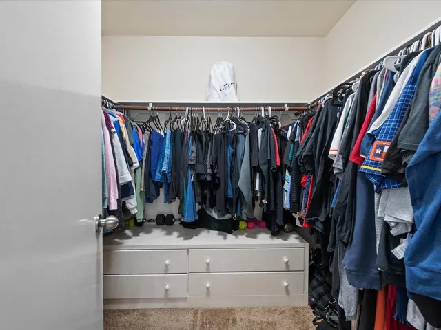 a view of walk in closet with clothes and shoes