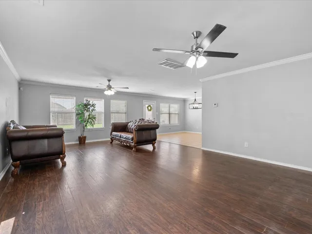 a living room with furniture and a wooden floor