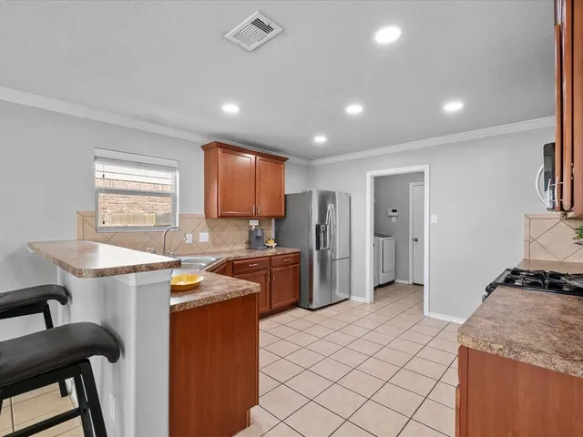 a kitchen with granite countertop a refrigerator stove top oven and sink