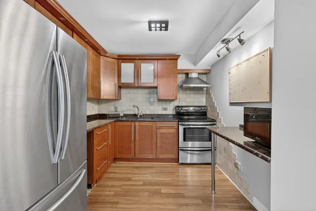a kitchen with stainless steel appliances granite countertop a stove a sink and a refrigerator