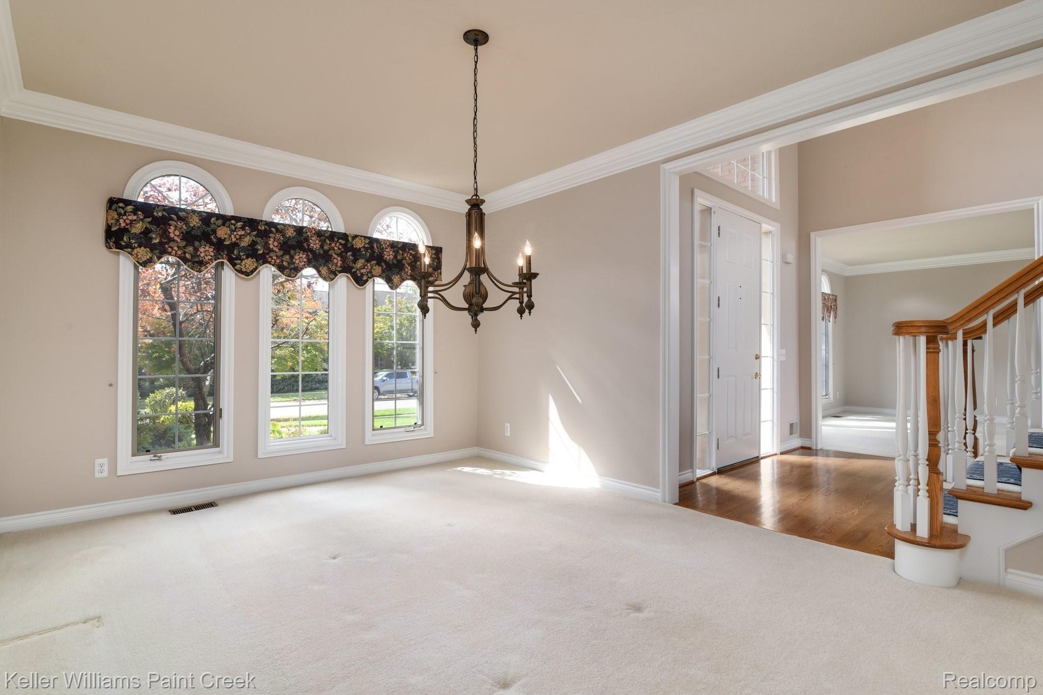 1163 Autumnview Drive Rochester, MI 48307 - Photo 13 of 34 The dining room offers an inviting ambiance with custom chandelier, crown molding and warm decor.