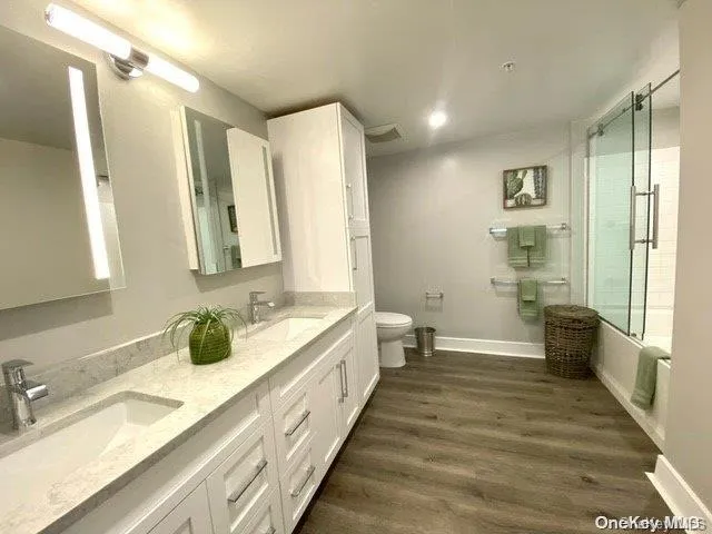 a bathroom with a double vanity sink a mirror and a bathtub