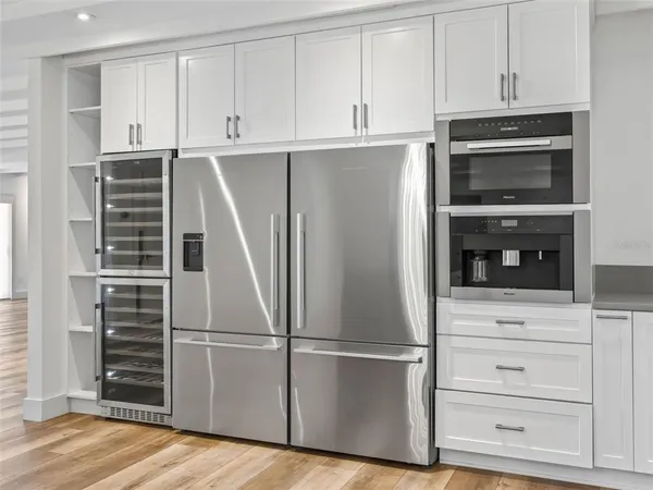 a kitchen with kitchen island granite countertop a stove a sink a dining table and chairs with wooden floor