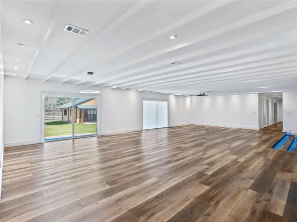 a living room with wooden floor and a window