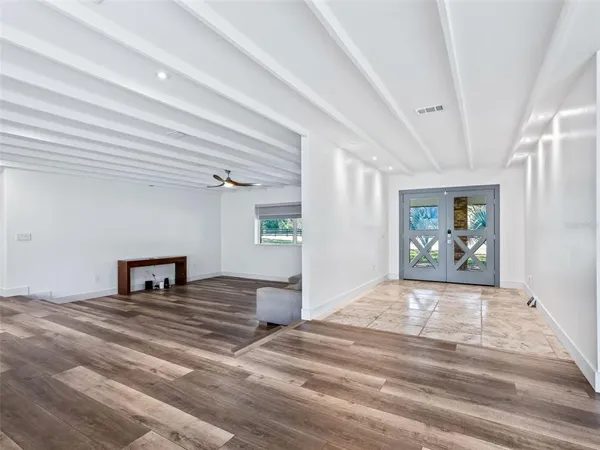 a spacious bathroom with a granite countertop sink a large mirror and a window
