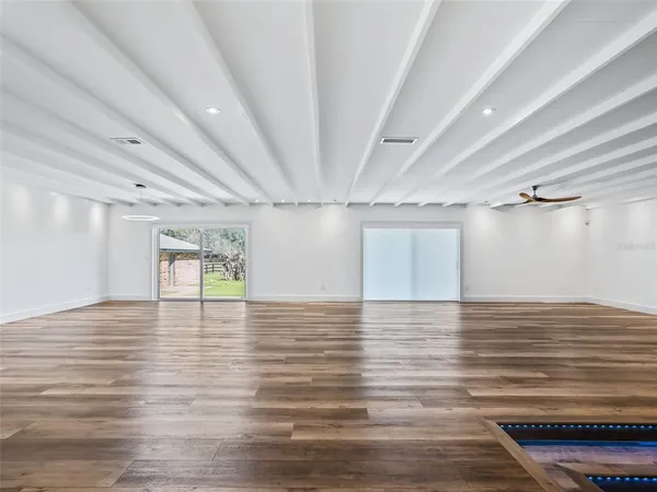 a kitchen with stainless steel appliances kitchen island granite countertop a stove a sink and white cabinets with wooden floor