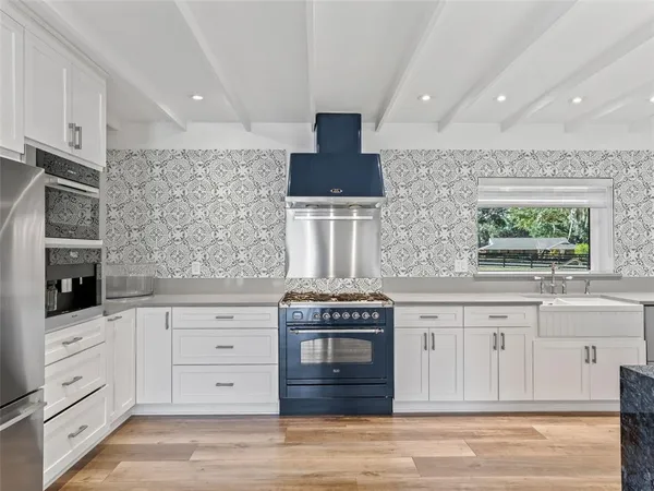 a kitchen with stainless steel appliances kitchen island granite countertop a refrigerator and stove