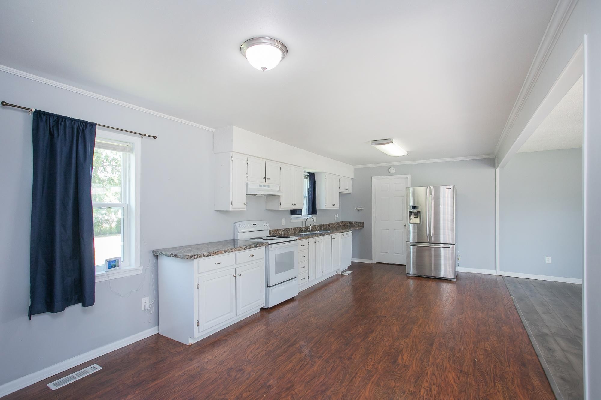 704 Miles Road Pulaski, TN 38478 - Photo 8 of 33 a large kitchen with a wooden floor and white cabinets