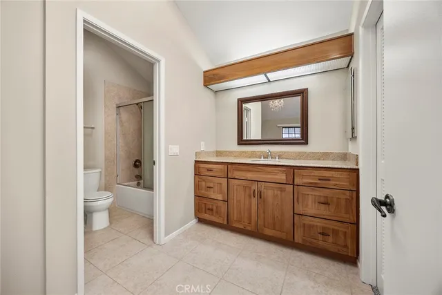 a bathroom with a granite countertop sink mirror and toilet