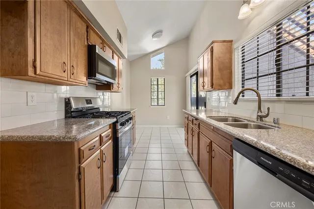 a kitchen with stainless steel appliances granite countertop a sink stove and cabinets