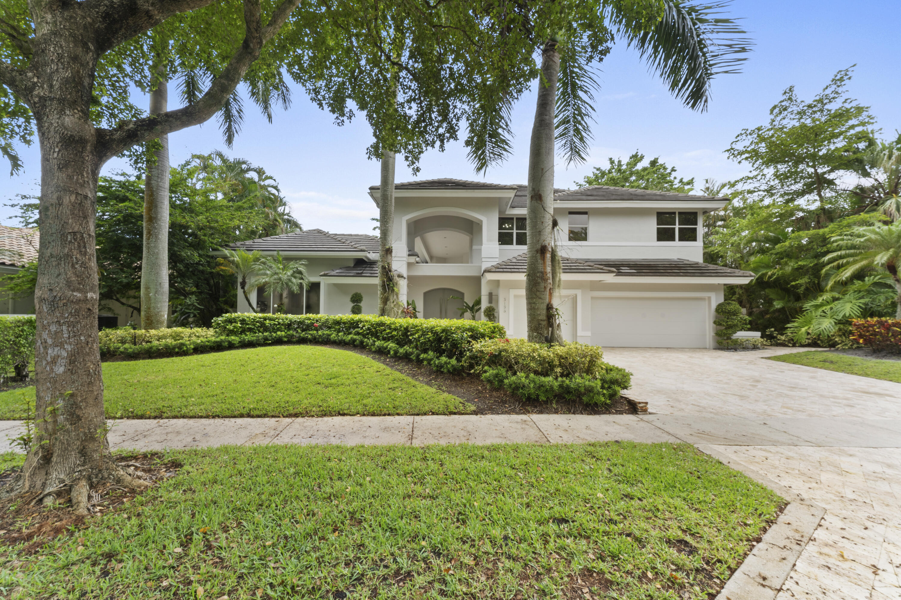3156 Northwest 61st Street Boca Raton, FL 33496 - Photo 2 of 46 a front view of a house with a garden