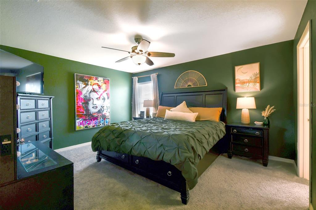 105 Blue Alice Spring Court Ruskin, FL 33570 - Photo 22 of 49 a bedroom with a bed dresser and a flat tv screen