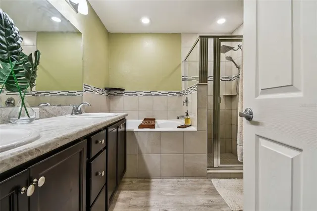 a bathroom with a granite countertop sink a mirror and a shower