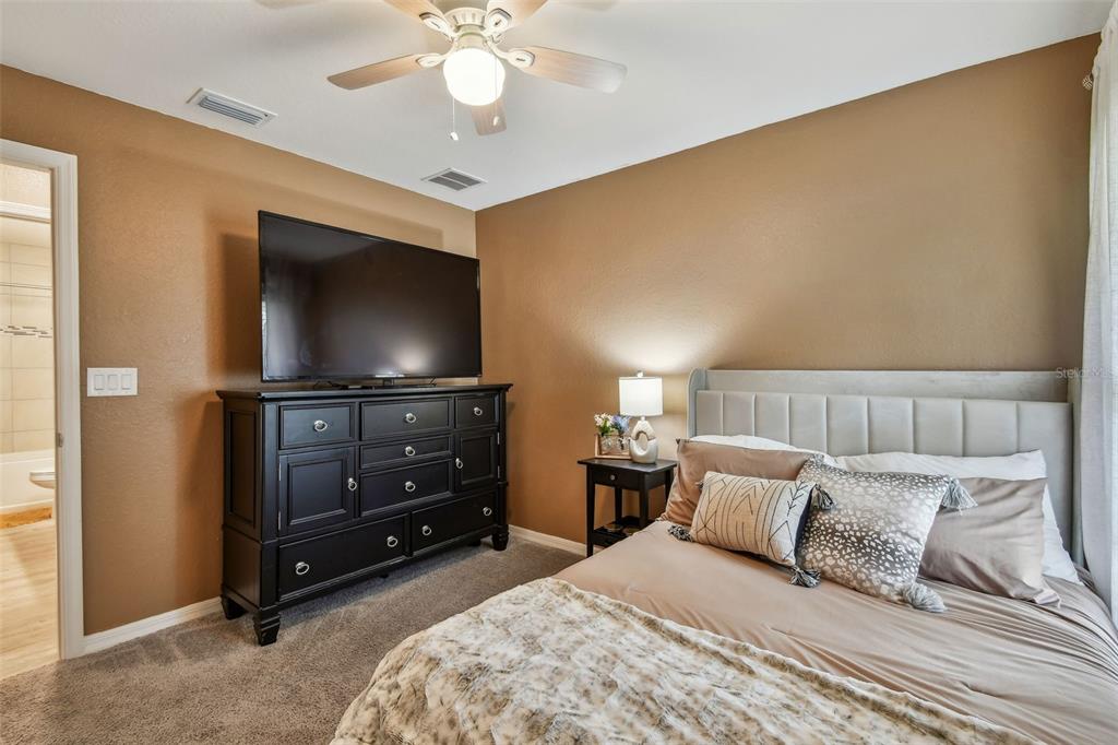 105 Blue Alice Spring Court Ruskin, FL 33570 - Photo 28 of 49 a bedroom with a bed and a flat screen tv