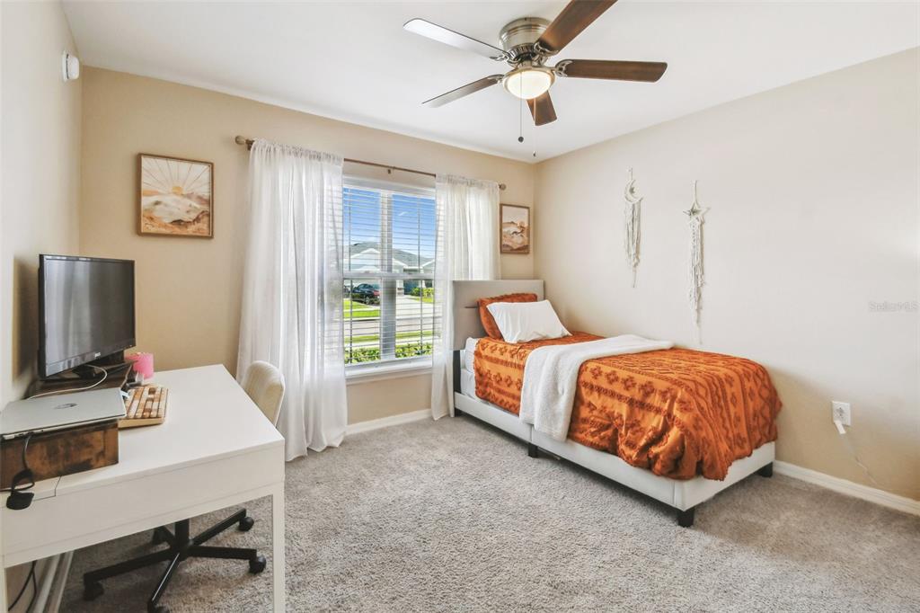 105 Blue Alice Spring Court Ruskin, FL 33570 - Photo 34 of 49 a bedroom with a bed window and a flat screen tv