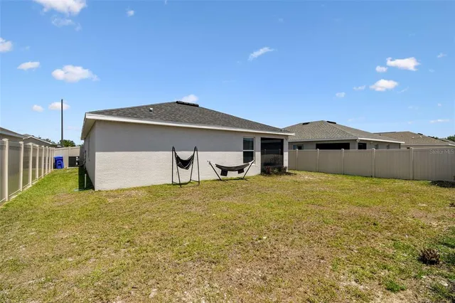 a view of a sign board with flower plants in front of it