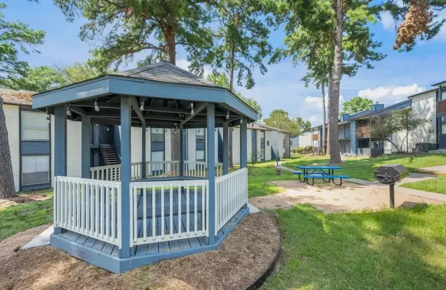 a view of a chair and table in backyard of the house