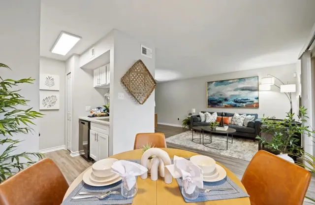 a living room with furniture and a painting on the wall