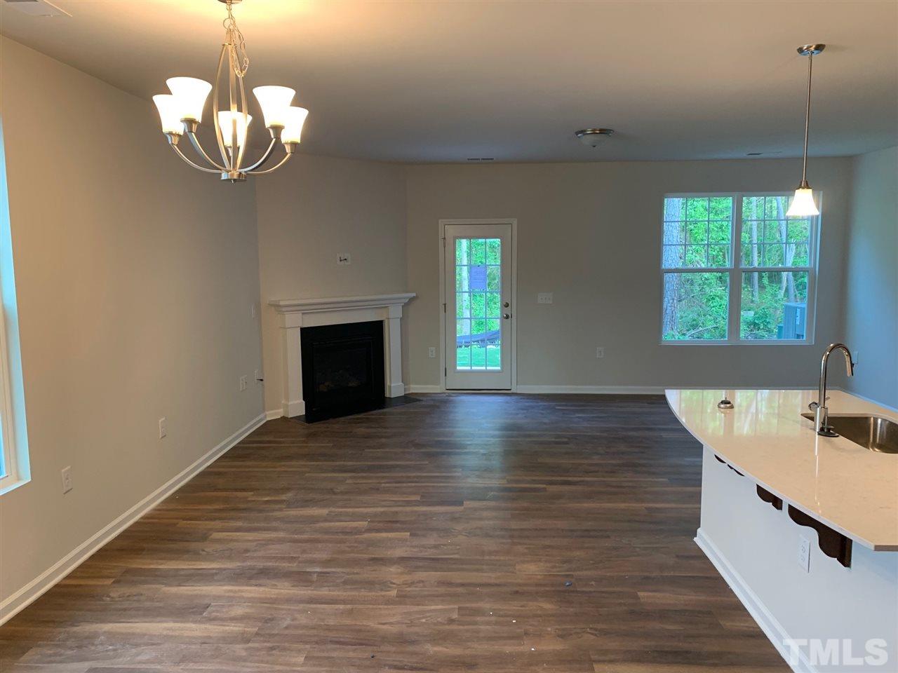 6141 Beale Loop, Unit 57 CARLTON Raleigh, NC 27616 - Photo 3 of 9 a view of a room with wooden floor and a fireplace