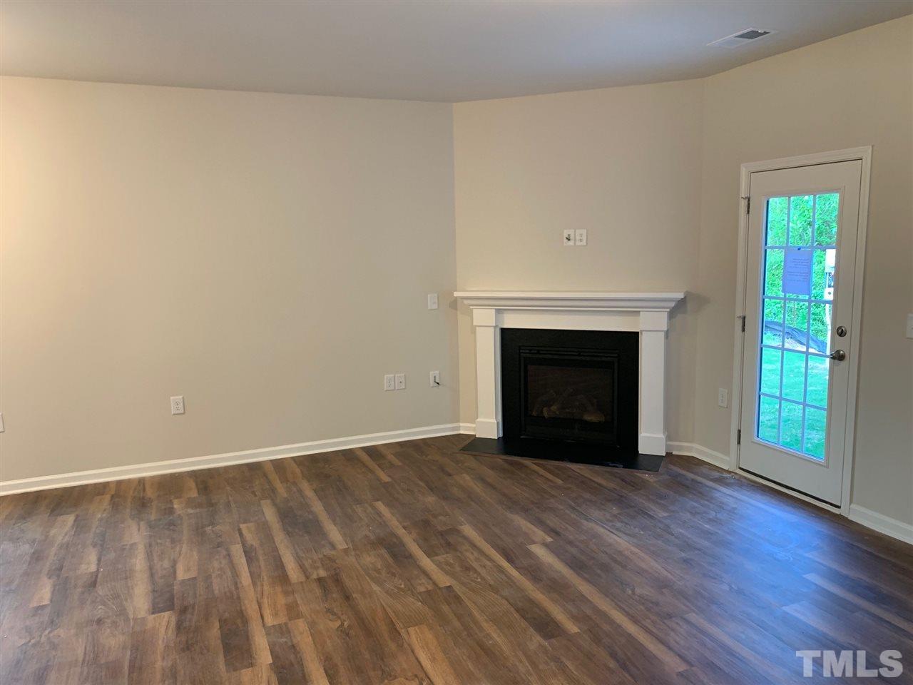 6141 Beale Loop, Unit 57 CARLTON Raleigh, NC 27616 - Photo 6 of 9 a view of empty room with wooden floor and fireplace