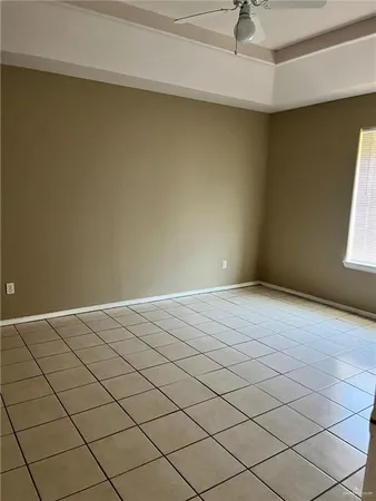 an empty room with windows and ceiling fan