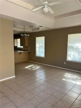 an empty room with a ceiling fan and window