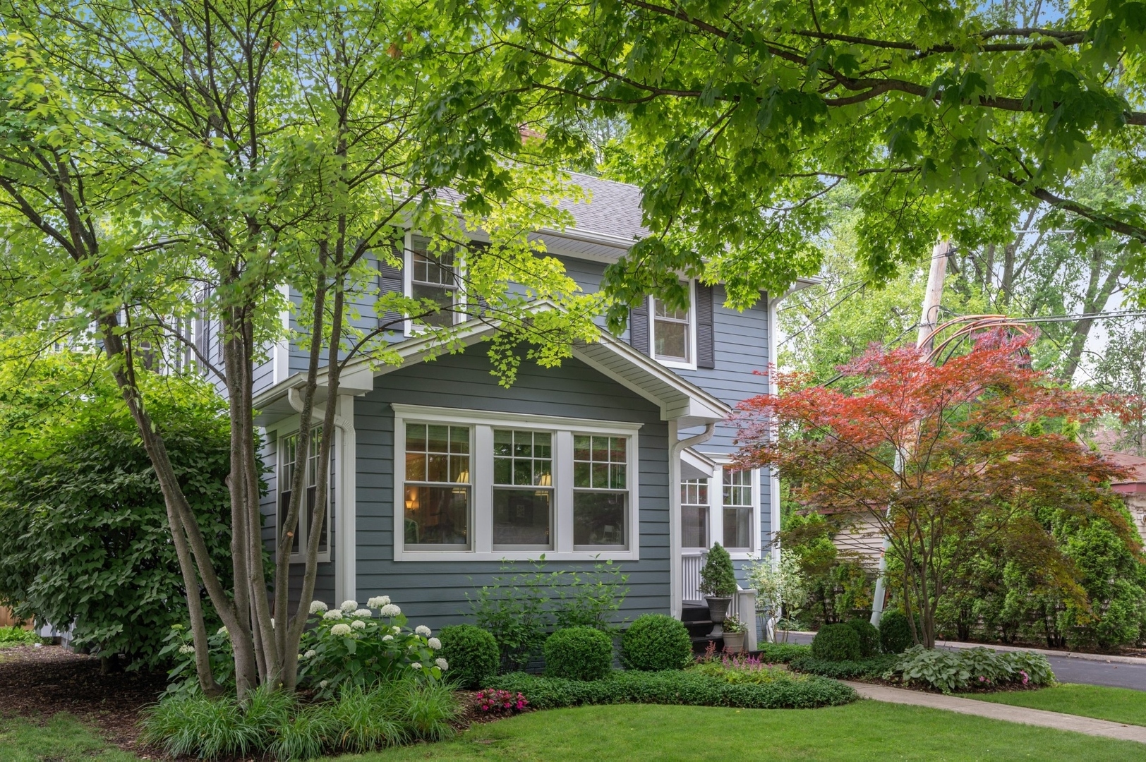 a front view of a house with a yard and trees