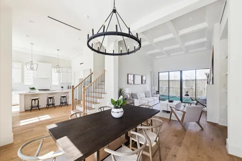 a dining room with furniture a chandelier and wooden floor