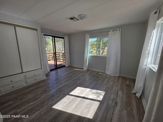 an empty room with windows and closet