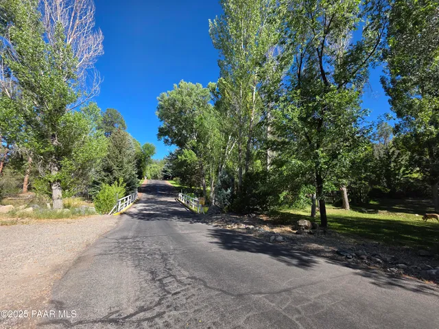 a view of a street with trees and bushes