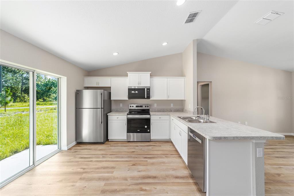17590 Southwest 112th Place Dunnellon, FL 34432 - Photo 16 of 31 a kitchen with stainless steel appliances granite countertop a refrigerator and a stove top oven