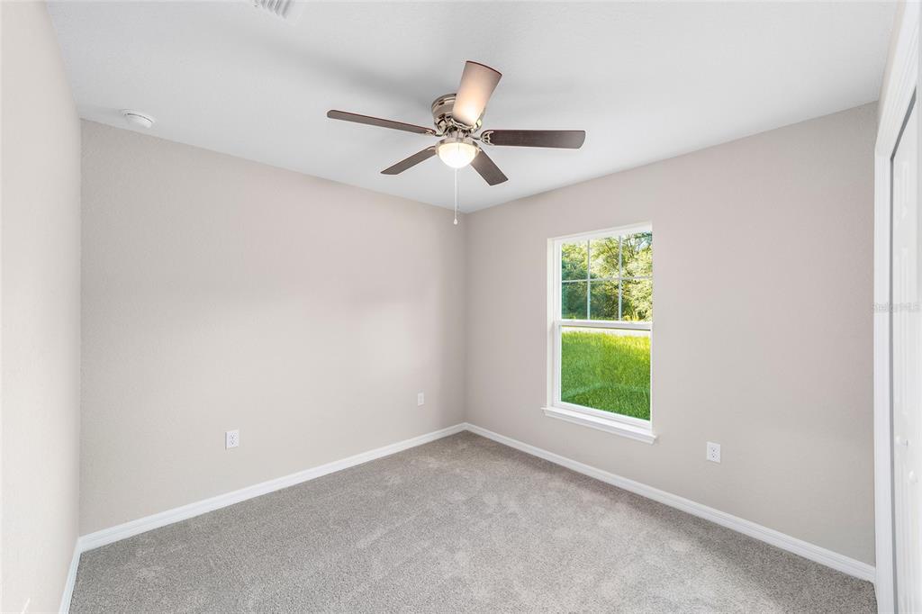 17590 Southwest 112th Place Dunnellon, FL 34432 - Photo 19 of 31 an empty room with windows and ceiling fan