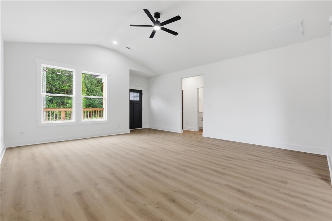 403 Tribble Street Seneca, SC 29678 - Photo 7 of 37 A spacious living area with vaulted ceilings and contemporary flooring, offering serene views of the outdoors.