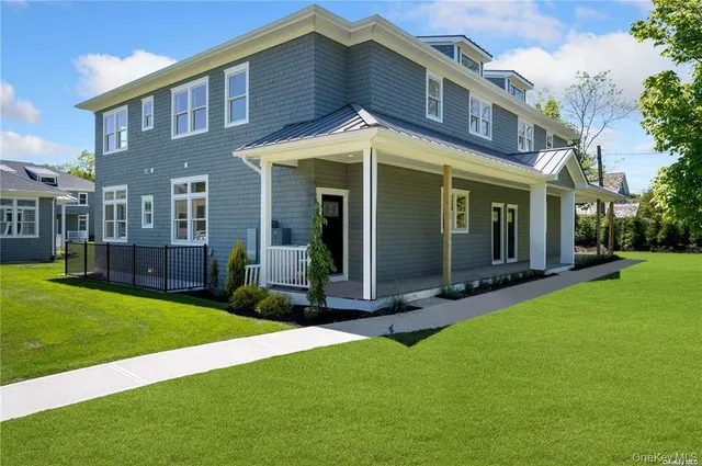 a view of a brick house with a yard and plants