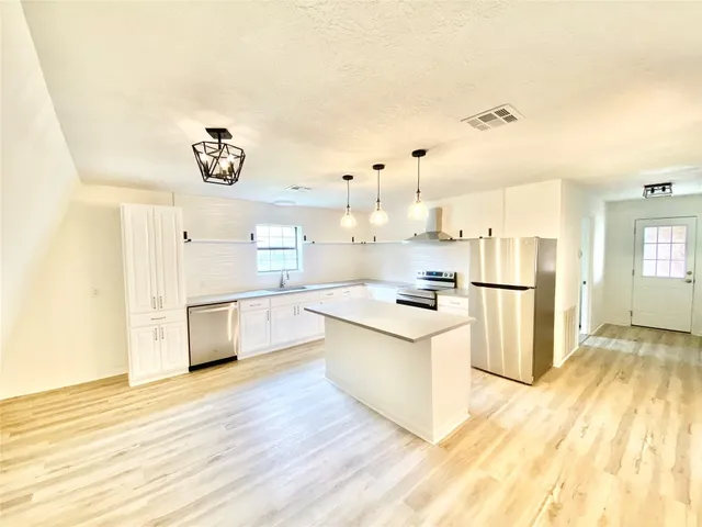 a kitchen with white cabinets and white appliances