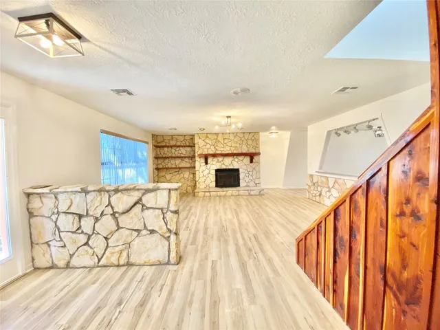 a view of a living room with wooden floor and staircase
