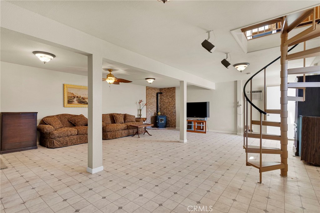 31420 Rabbit Springs Lane Lucerne Valley, CA 92356 - Photo 35 of 72 a living room with furniture a flat screen tv and a large window