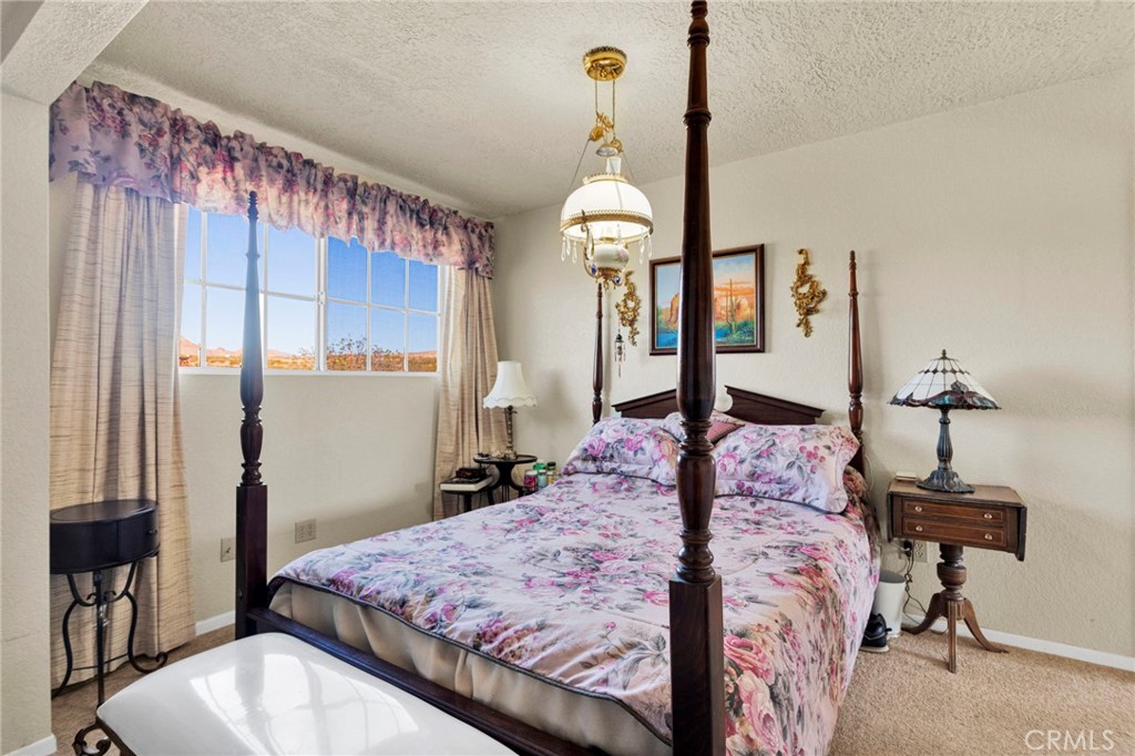 31420 Rabbit Springs Lane Lucerne Valley, CA 92356 - Photo 58 of 72 a bedroom with a bed and a chandelier