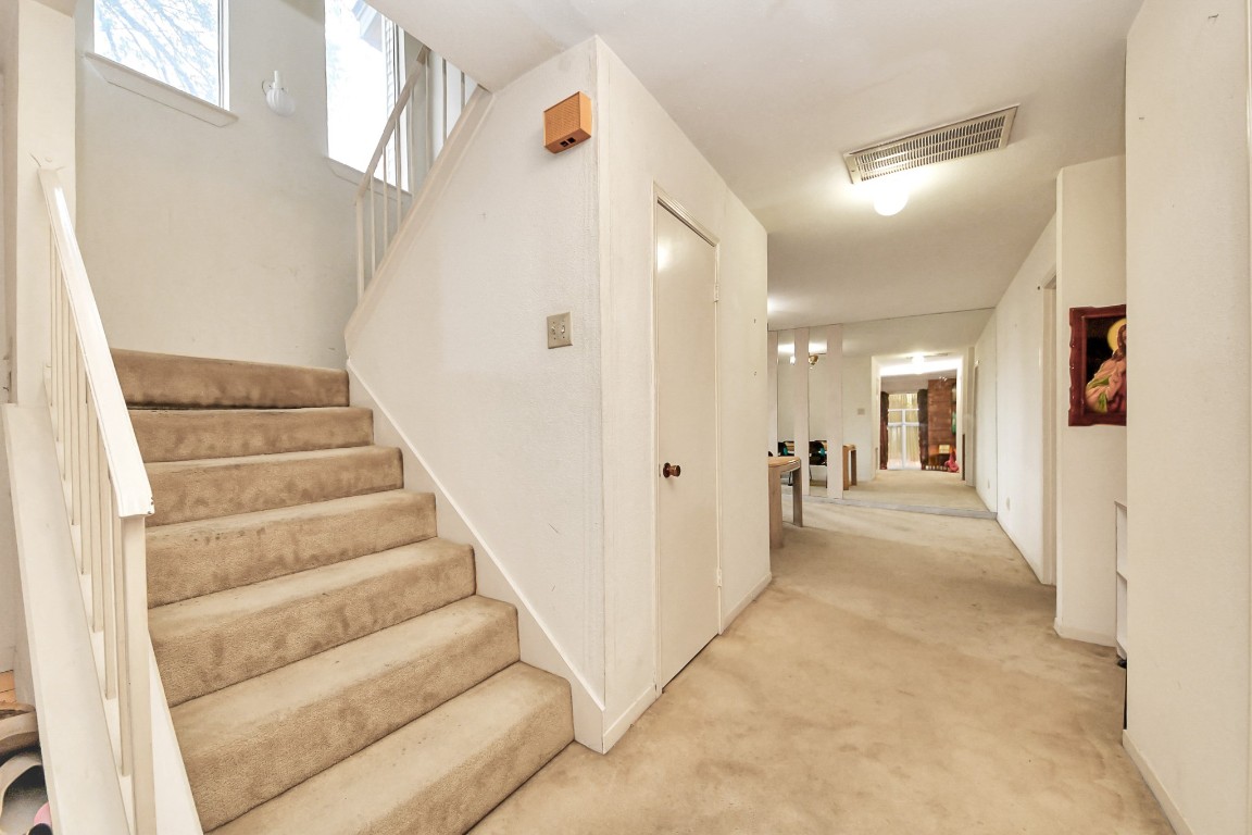 7728 Challie Lane Houston, TX 77088 - Photo 15 of 28 a view of a hallway with white walls and stairs