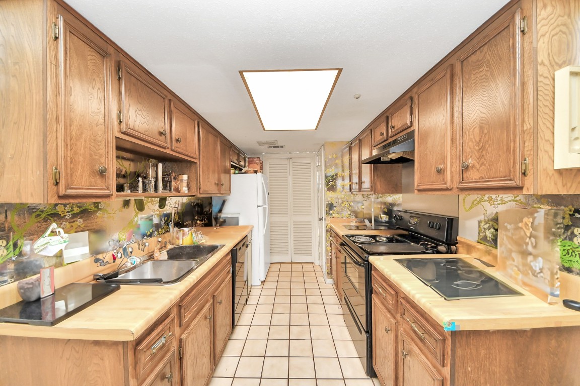 7728 Challie Lane Houston, TX 77088 - Photo 4 of 28 a kitchen with a sink stove and refrigerator