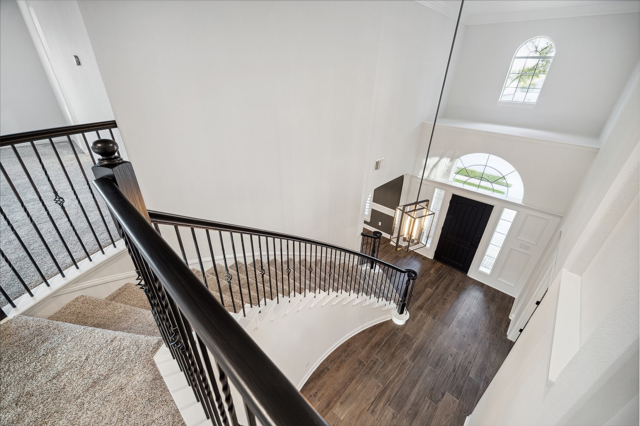 6211 Alameda Point Lane Houston, TX 77041 - Photo 28 of 50 Stunning staircase featuring iron balusters, and a sweeping curved design leading to the expansive upstairs landing that connects the grand entry to the game room, media room, and four secondary bedrooms above.