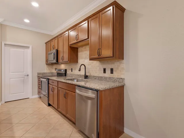 a kitchen with a sink a counter space appliances and cabinets