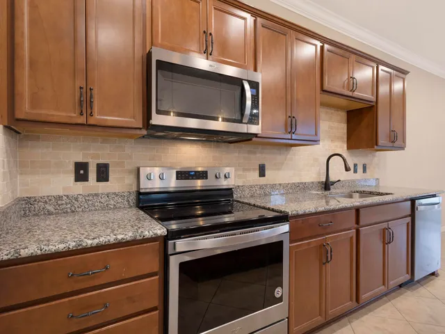 a kitchen with stainless steel appliances granite countertop a sink a counter top space and cabinets