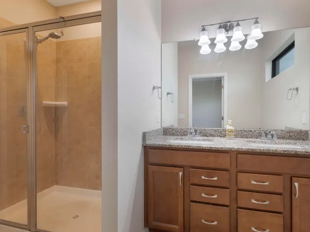a bathroom with a granite countertop sink and shower