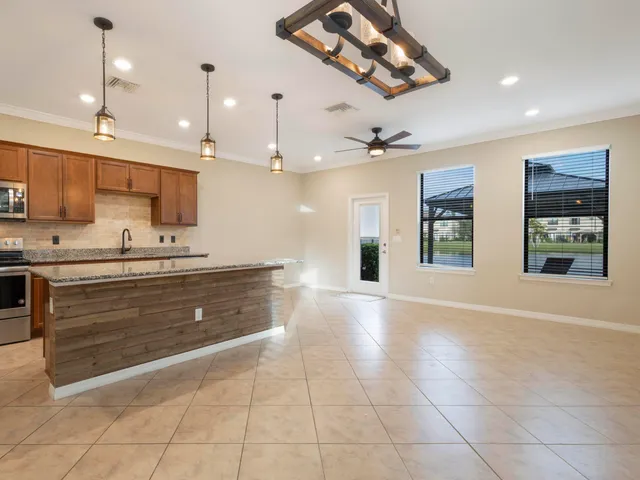 a view of an empty room with a window and a kitchen