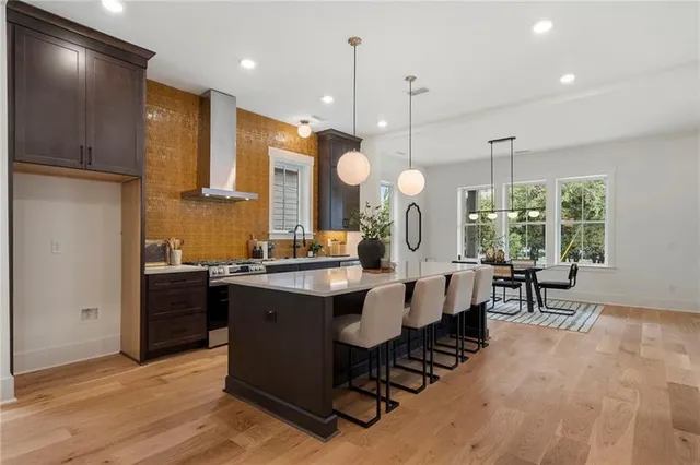 a kitchen with kitchen island granite countertop a stove a sink a dining table and chairs