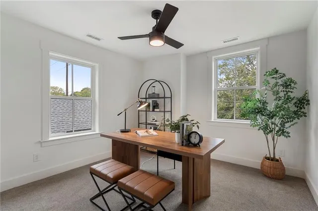 a roof deck with a couple of chairs and a potted plant
